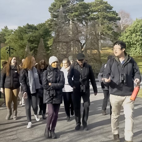 Birding guide Woo Sung Park leads participants on a bird tour in the New York Botanical Garden. Photo: Tank Brain Productions