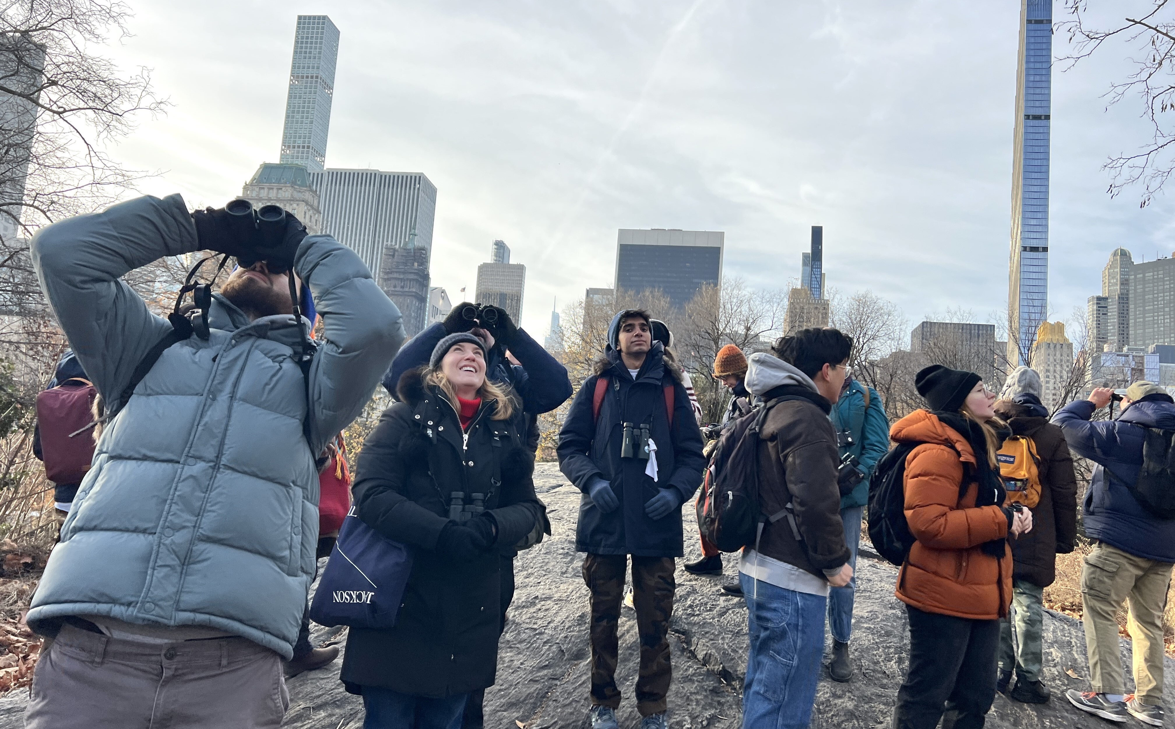 A group of Christmas Bird Count volunteers look all around, with a dramatic Central Park South skyline behind them. Photo: NYC Bird Alliance